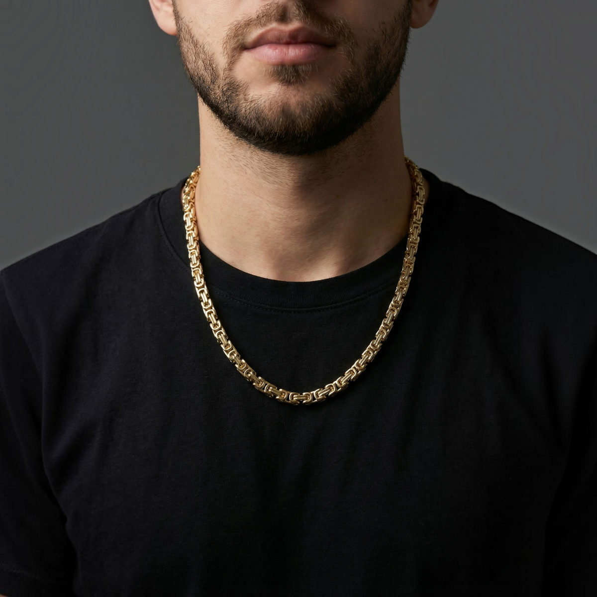 Cadena de tejido bizantino de El Rey Joyero en oro laminado 18k, 6mm de ancho, lucida por un hombre con camiseta negra.