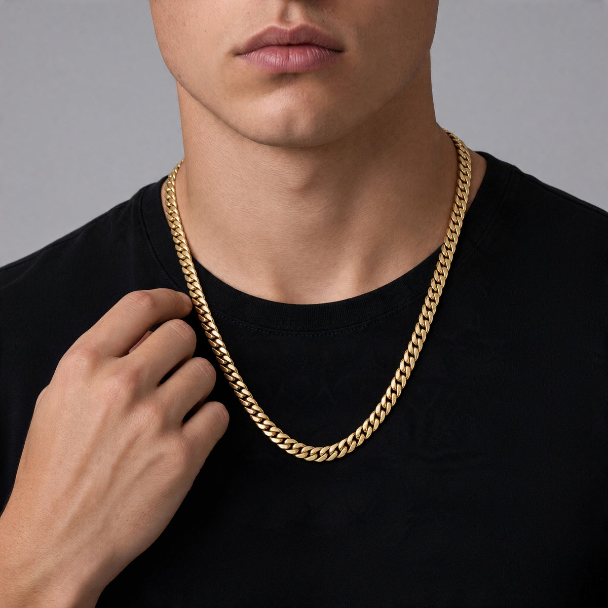 Cadena tipo cubana de El Rey Joyero en oro laminado con eslabones entrelazados sobre camiseta negra