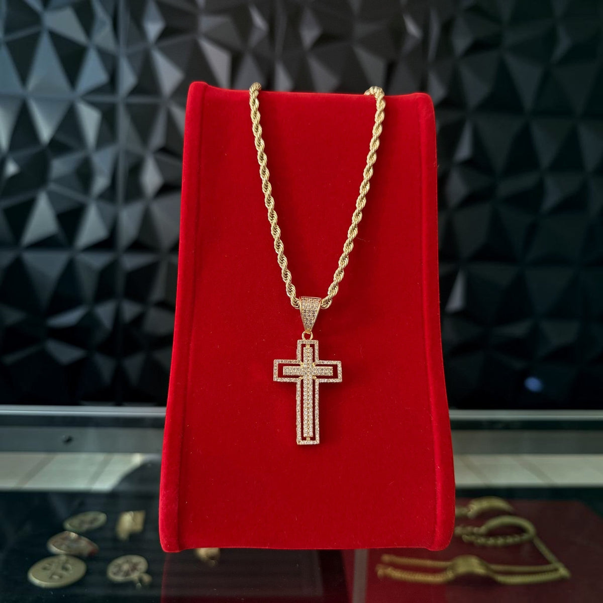 Kit de cadena y dije de cruz con diamantes El Rey Joyero en oro sobre exhibidor de terciopelo rojo