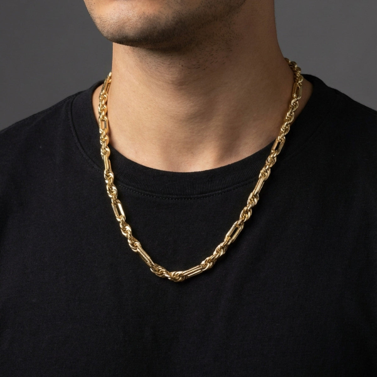 Cadena Fígaro Premium de El Rey Joyero en oro laminado 18k, eslabones brillantes sobre camiseta negra de hombre