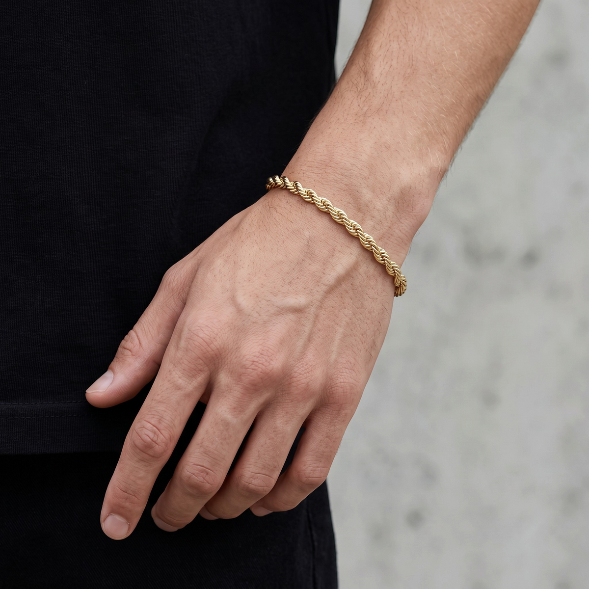 Pulsera tipo torzal de 5mm en oro laminado 18k de El Rey Joyero, lucida en la muñeca de un hombre.