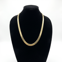 Cadena serpiente de El Rey Joyero en oro laminado 18k, diseño plano de 6mm sobre busto expositor negro.