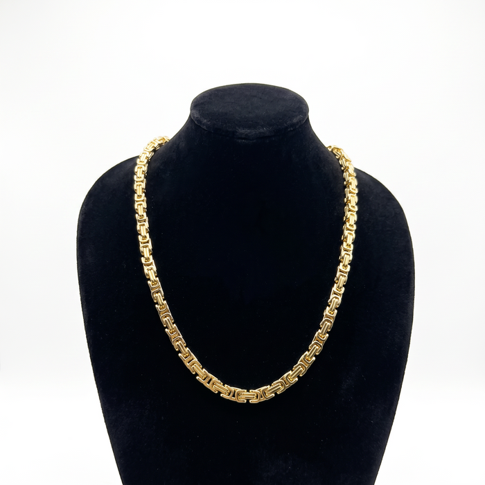 Cadena de tejido bizantino en oro laminado 18k de El Rey Joyero, 6mm de ancho, exhibida sobre un busto negro.