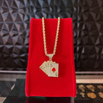 Kit de cadena torzal y dije de baraja con baño de oro 18k de El Rey Joyero sobre expositor de terciopelo rojo