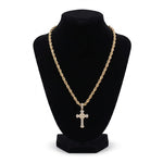 Set de cadena y dije de cruz El Rey Joyero en baño de oro 18k con diseño trenzado sobre maniquí negro