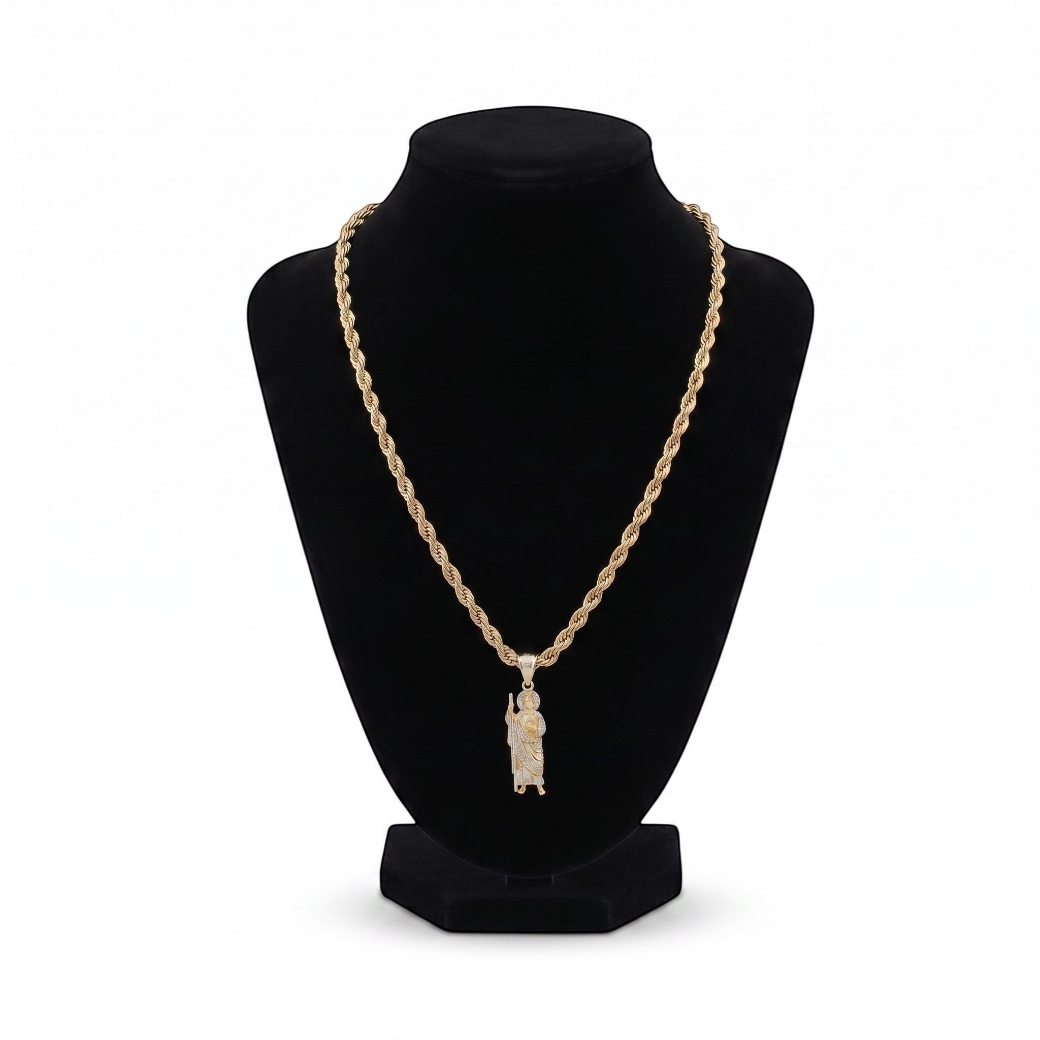 Kit de cadena y dije de San Judas adiamantado en oro laminado 18k de El Rey Joyero sobre busto expositor negro.