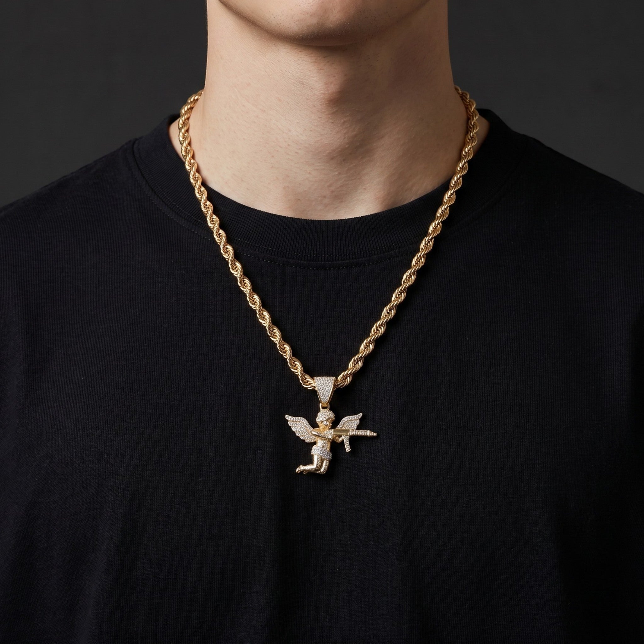 Collar El Rey Joyero con cadena torzal y dije de ángel con arma en baño de oro 18k sobre camiseta negra