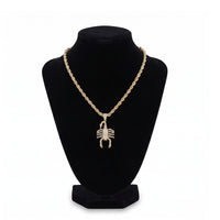 Collar con dije de escorpión en baño de oro 18k de El Rey Joyero sobre busto expositor negro
