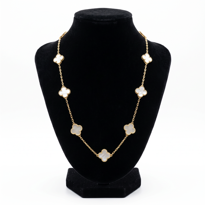 Collar El Rey Joyero estilo VC con eslabones dorados y dijes de trébol en nácar blanco sobre busto expositor negro.