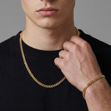 Conjunto de cadena y pulsera estilo Mónaco en baño de oro 18k de El Rey Joyero sobre un modelo con camiseta negra