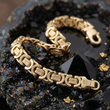 Pulsera de eslabones bizantinos de El Rey Joyero en oro laminado con cierre de mosquetón sobre piedra negra brillante