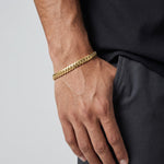 Pulsera estilo cubano de El Rey Joyero en oro laminado 18k, 6mm de ancho, lucida en la muñeca de un hombre.