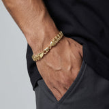 Pulsera de eslabones estilo chino en oro laminado 18k de El Rey Joyero, gruesa y brillante en la muñeca de un hombre.