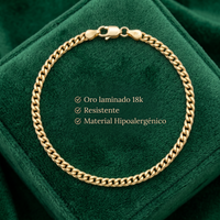 Pulsera Mónaco delgada de El Rey Joyero en oro laminado 18k sobre un estuche de terciopelo verde esmeralda.