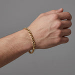 Pulsera tipo eslabón Mónaco de El Rey Joyero en oro laminado 18k de 5mm, lucida en la muñeca de un hombre.