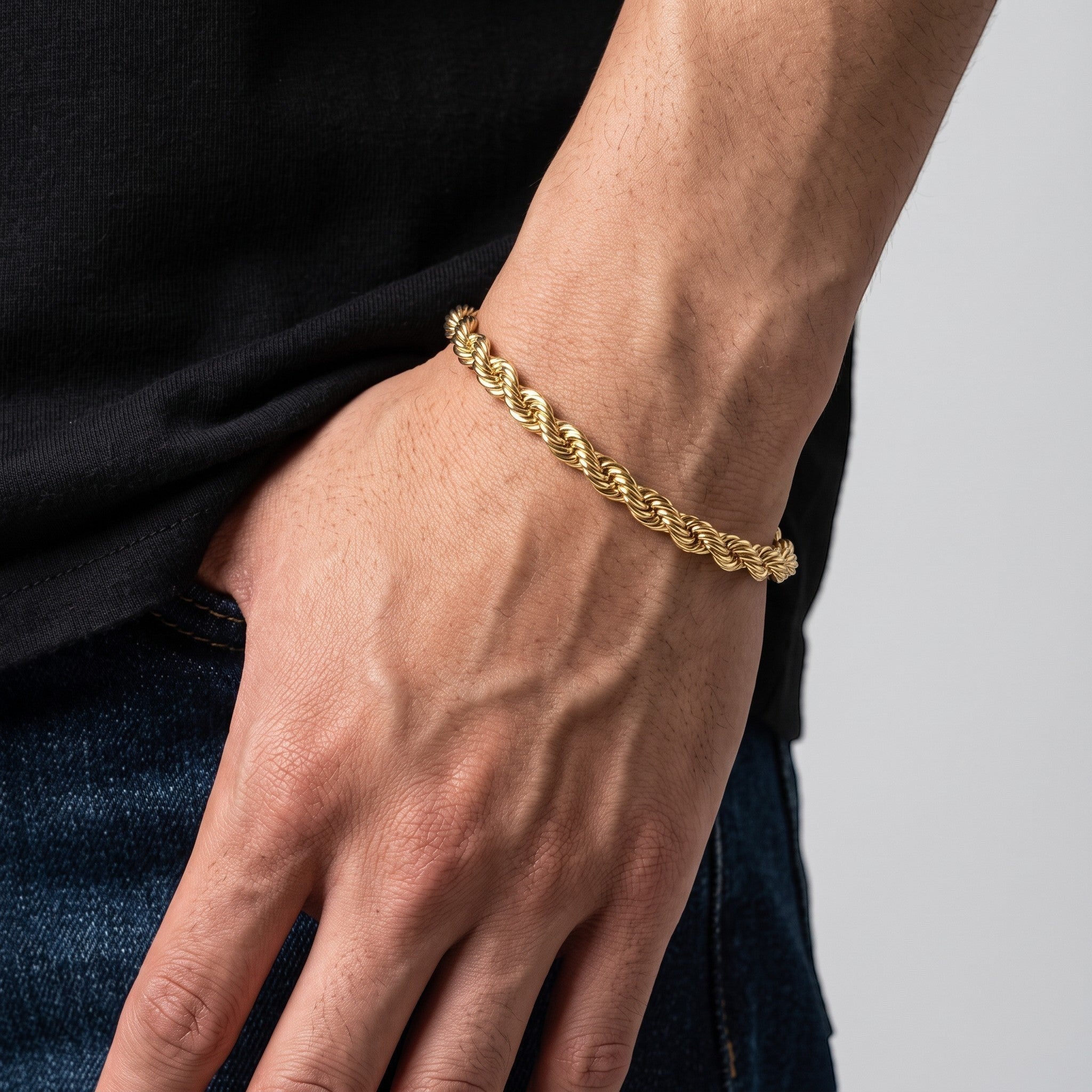 Pulso torzal delgado de El Rey Joyero en oro laminado 18k con eslabones trenzados en la muñeca de un hombre.