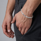 Pulso torzal de 6mm en plata .925 sólida de El Rey Joyero lucido en la muñeca de un hombre con pantalón gris