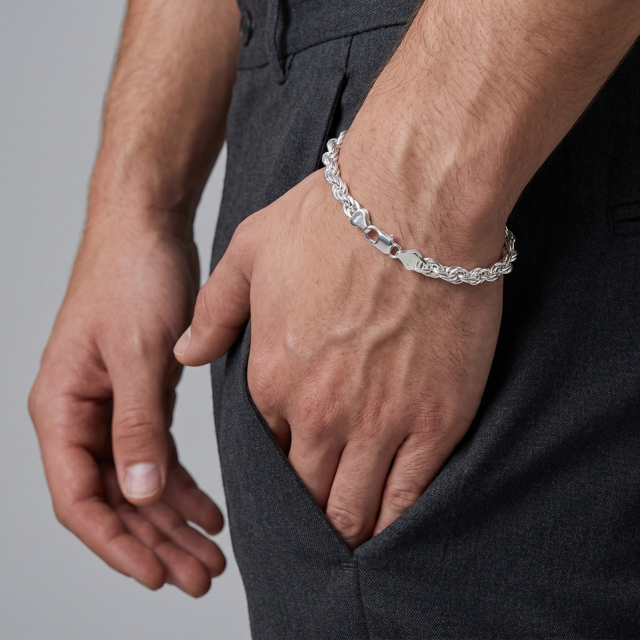 Pulso torzal de 6mm en plata .925 sólida de El Rey Joyero lucido en la muñeca de un hombre con pantalón gris