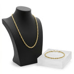 Set de cadena y pulsera torzal en baño de oro 18k de El Rey Joyero sobre expositor negro y base acrílica