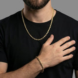 Set de cadena y pulsera torzal El Rey Joyero con baño de oro 18k, lucido por un hombre con camiseta negra.